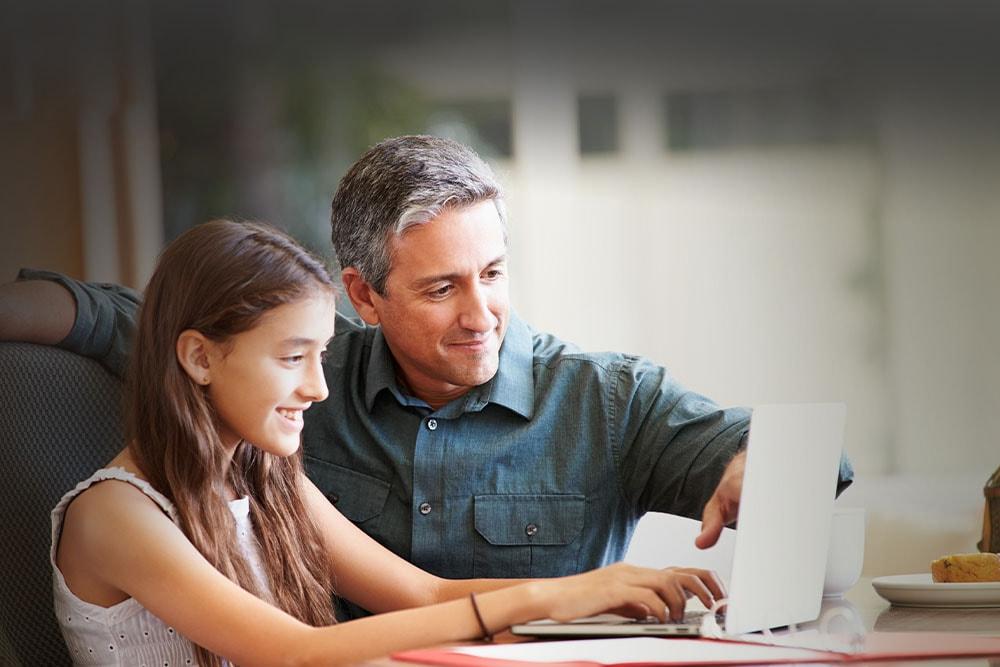 Female student in a white shirt smiling at the camera taking an online class with her learning partner at Springs Connections Academy. 